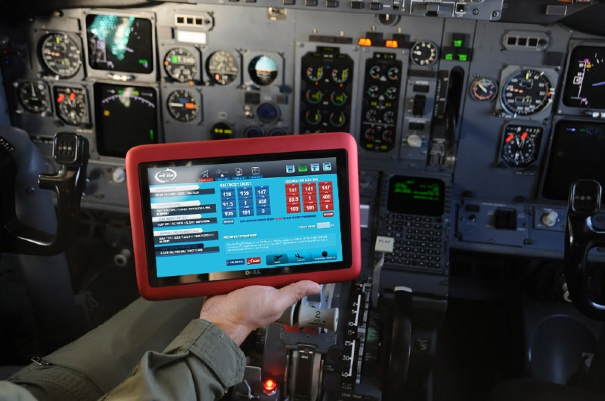 Pilot holding a tablet showing takeoff speeds in the cockpit